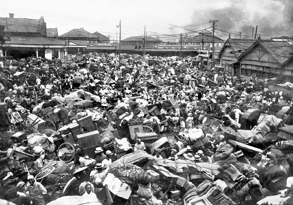 A plaza in front of Tokyo's Ueno Station is inundated with people carting furniture and other belongings and trying to flee after the Kanto Earthquake.