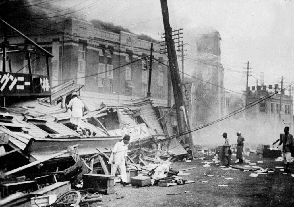 Emberek túlélőket keresnek egy összeomlott irodaházban az 1923-as nagy Kanto földrengés után.