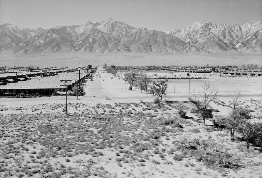 Bird’s-eye view of center grounds showing buildings, roads and mountains in background.