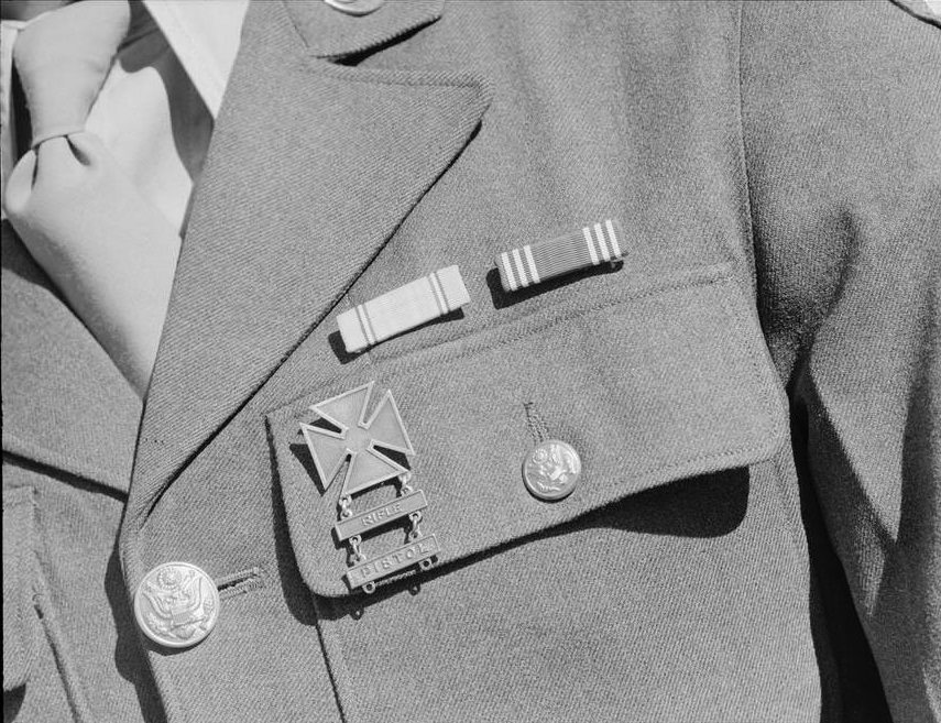 Service ribbons and qualification badge above pocket of military uniform worn by Corporal Jimmie Shohara.