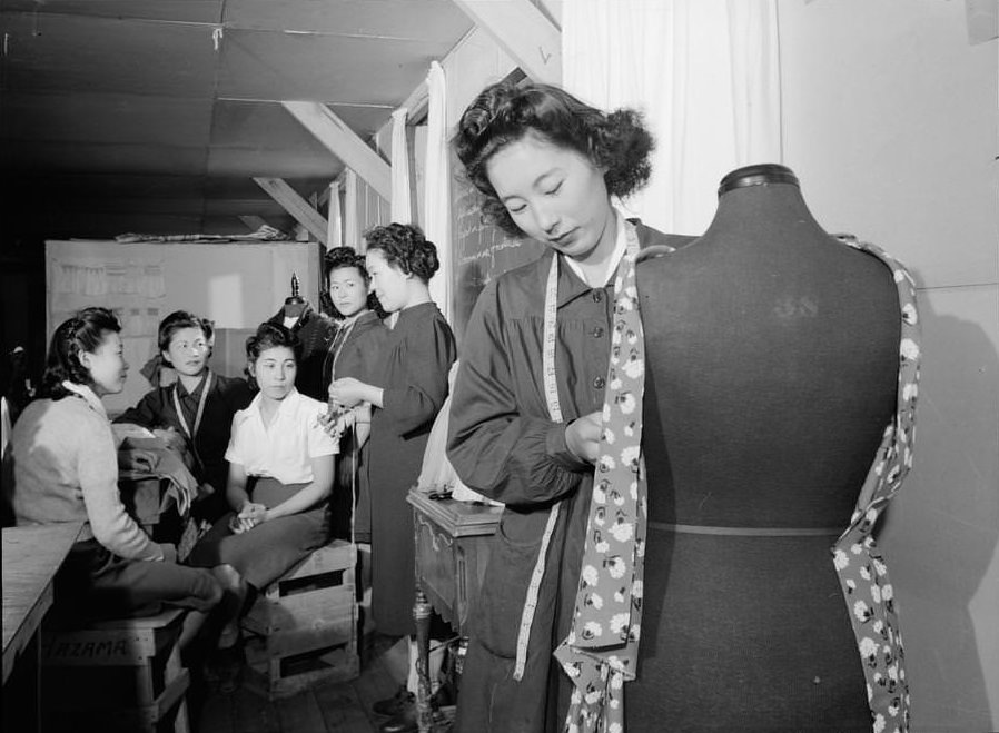 Mrs. Ryie Yoshizawa, instructor, standing in front of class of women students, one woman in foreground with dressmaker’s dummy.