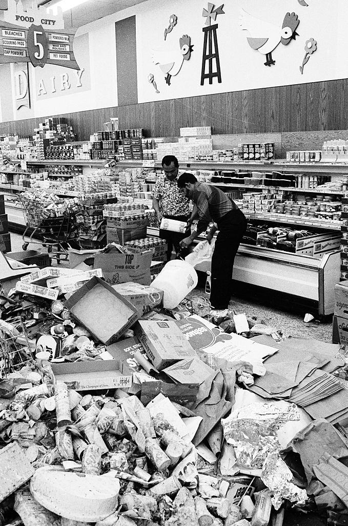 Interior of the Food City supermarket at Walton Ave. and East Burnside Ave. in the Bronx with spoiled food and looted discards as clerks restock the shelves, New York City, July 13, 1977.