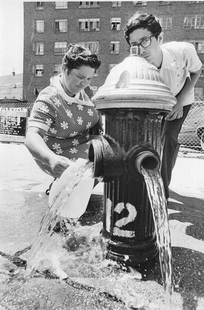 A woman taking water from a fire hydrant along 1st Avenue in East Harlem during the blackout on July 14, 1977.