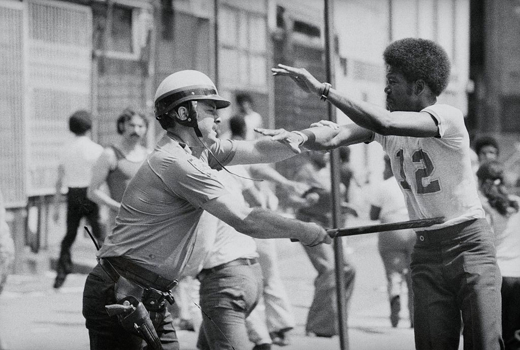 Egy rendőr a zsákmányt a New York-i Brookly, Bushwick szakaszában, 1977. július 13-án veszi át.