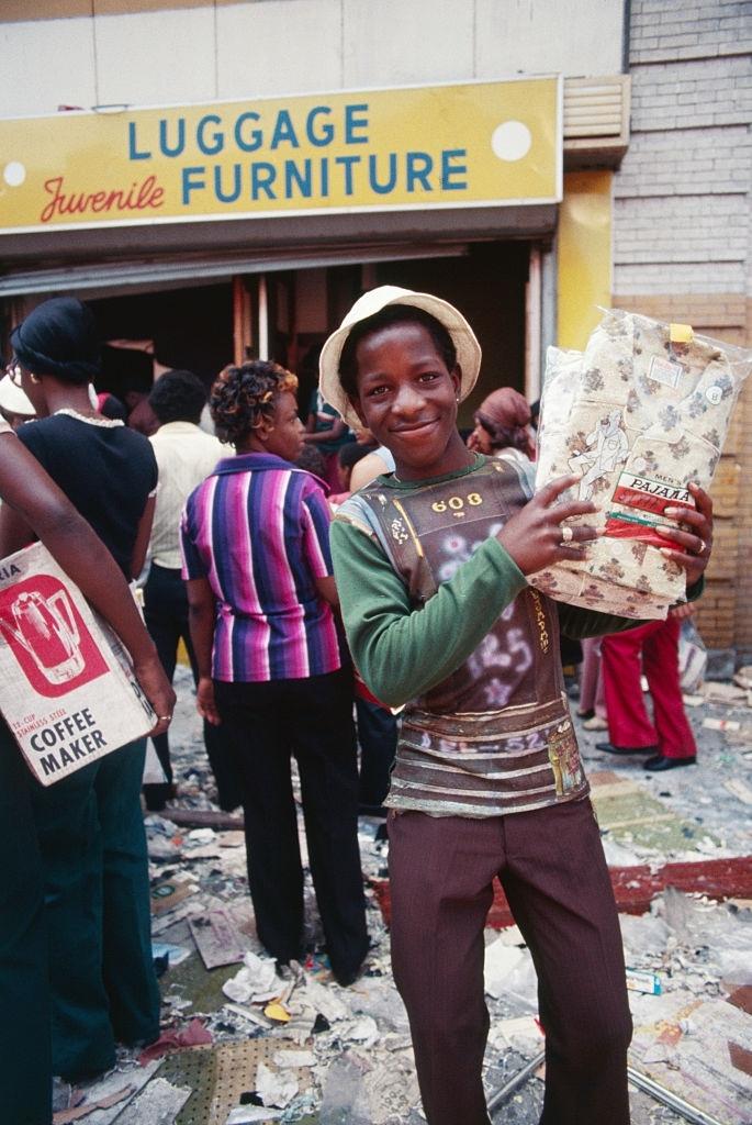 Egy fiatal fosztogató feltart egy pár pizsamát, amelyet a New York City Brooklyn Bushwick részének üzletéből, 1977. július 13-án vett.