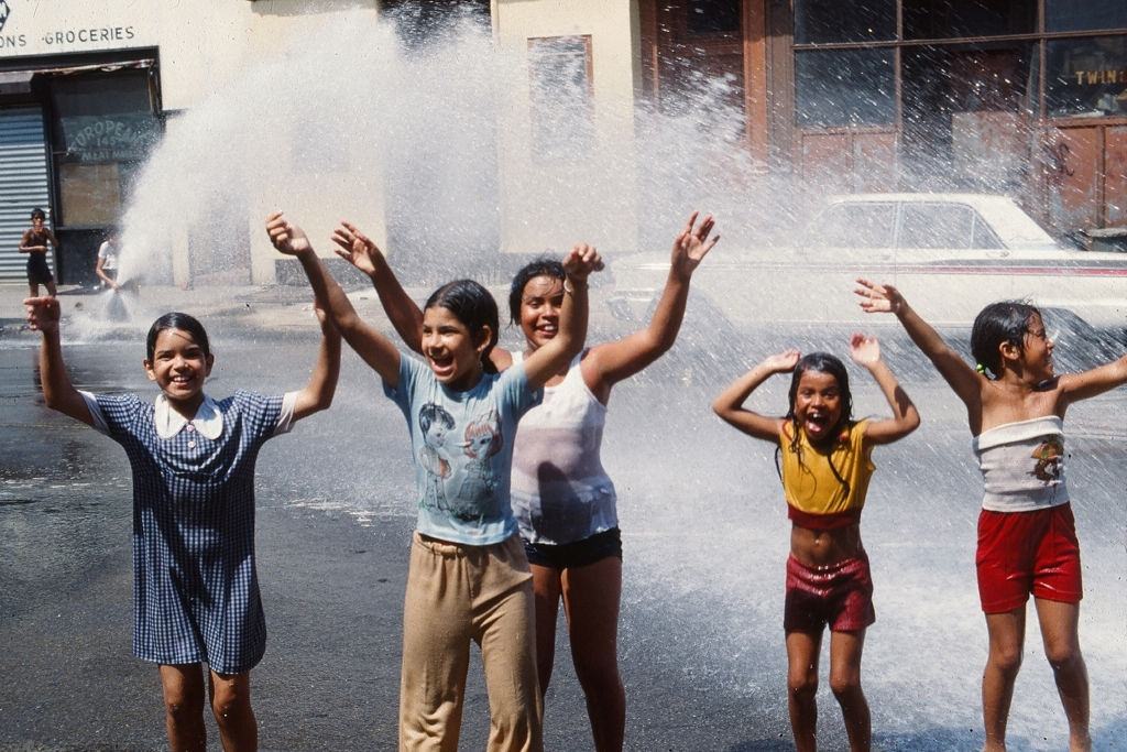 A group of young girls play in the water from an opened fire hydrant after the blackout of 1977.
