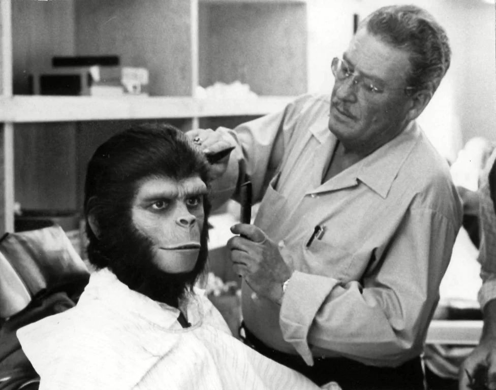Actor Roddy McDowall gets his wig adjusted by an unidentified makeup artist on the set of the film.