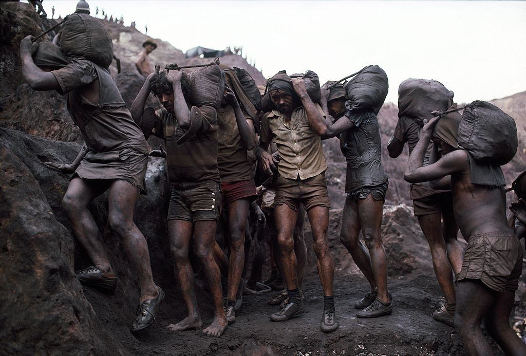 Mine workers haul out 40-pound bags of ore from their owners mining claims July 15, 1985 in Serra Pelada, Brazil.