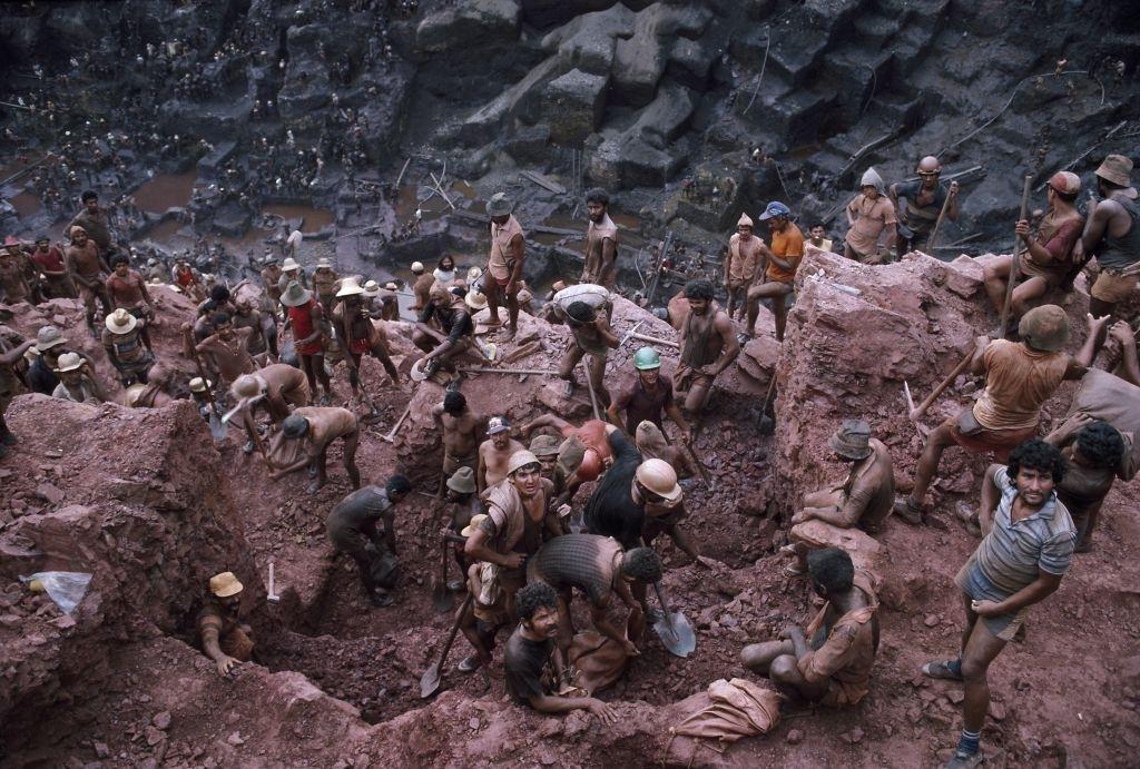 Mine workers use picks and shovels to break up ore in single plot claims of 6.6 feet by 9.8 feet in Serra Pelada, Brazil.