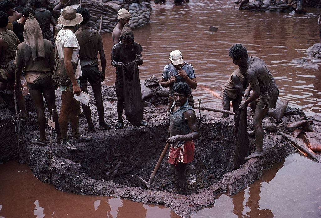 Mine workers dig ore from a plot at the bottom of the Serra Pelada, Brazil gold mine.