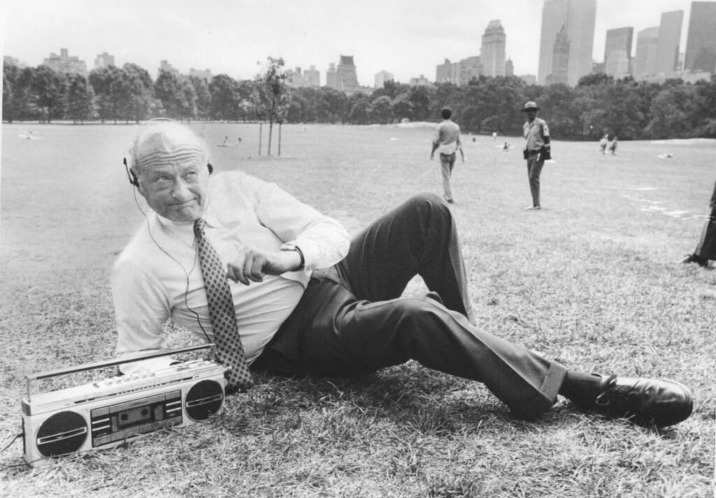 Mayor Ed Koch listens to boom box with headphones, 1985