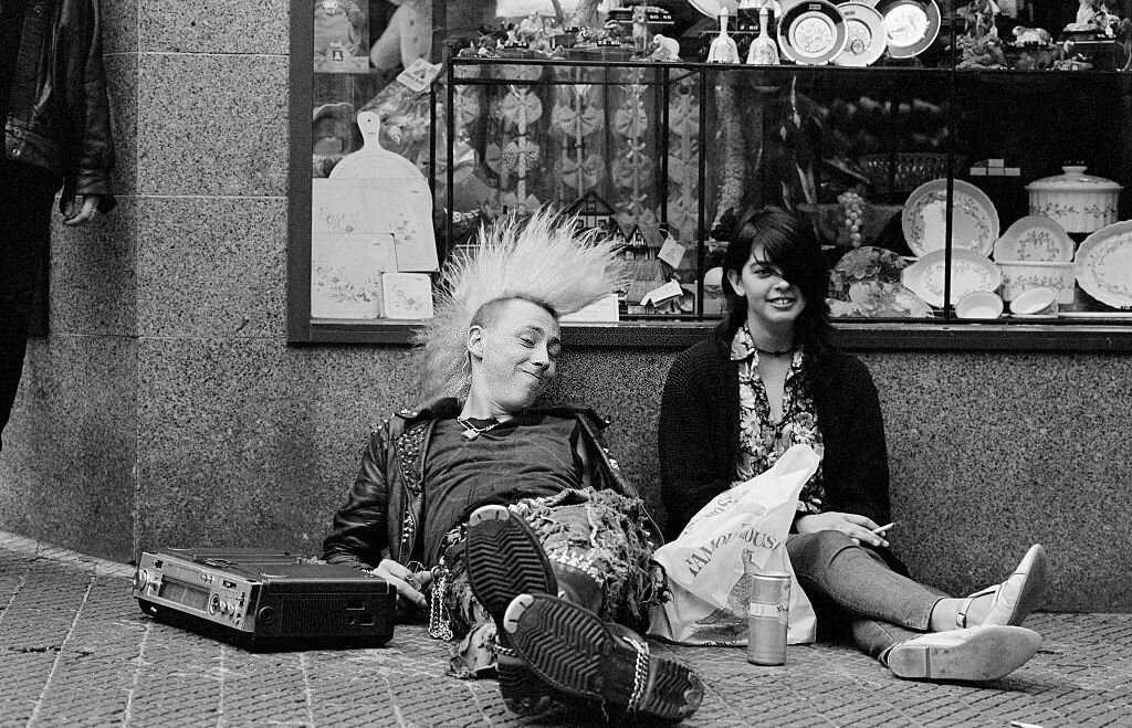 A young Punk, sitting in the street with a girl listening to music, 1986