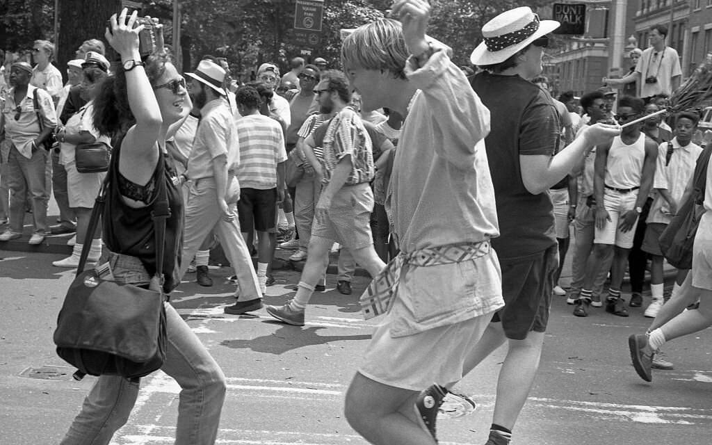 A woman holding a boombox her head, and a man dance in the middle of the street, 1989