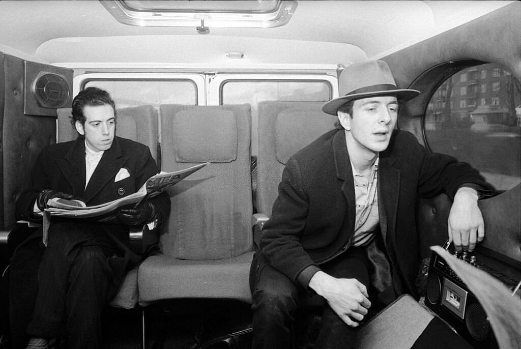 Mick Jones and Joe Strummer with a boombox, in their tour bus before a concert at De Montfort Hall, 1980