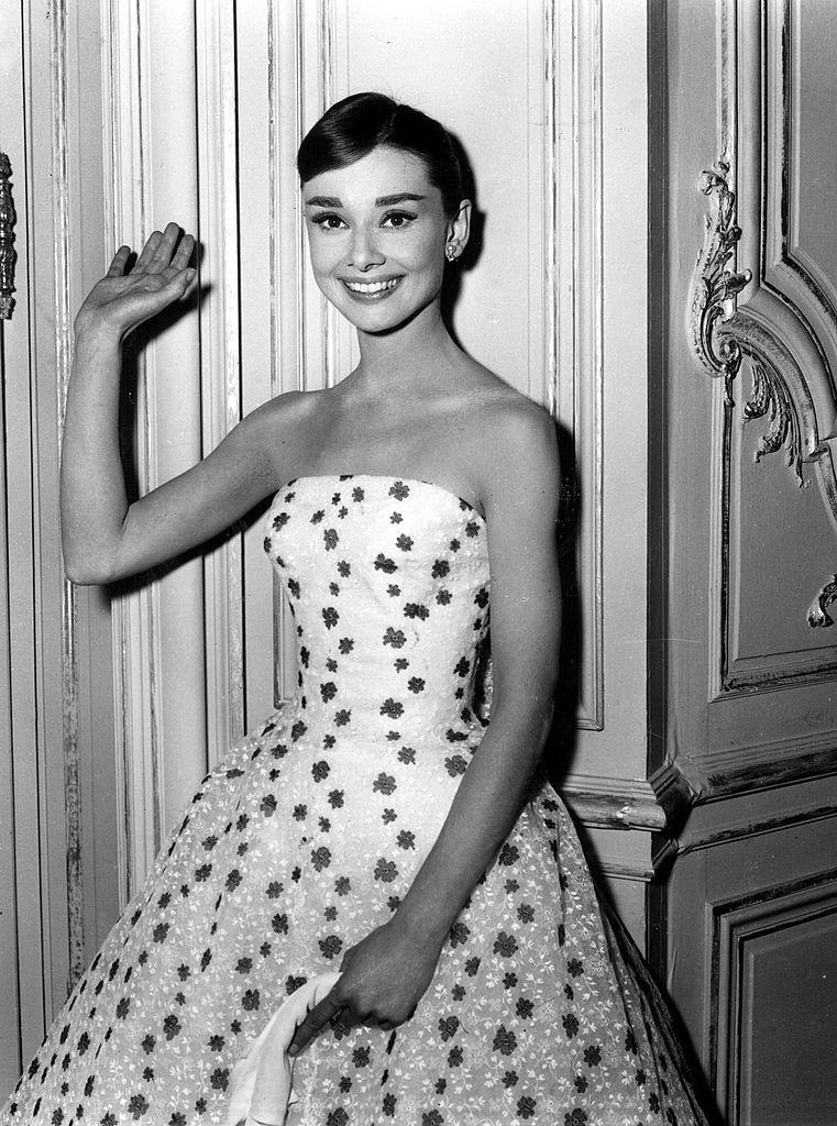 Audrey Hepburn waves at the camera, 1950s.