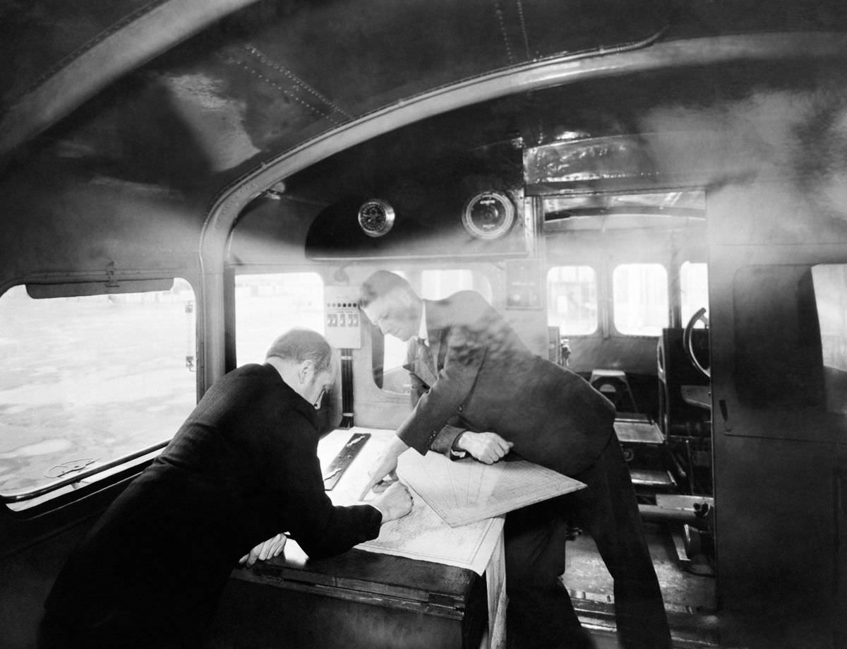The chief navigator examines a map in the navigation cabin,c. 1930