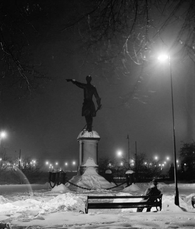 A homeless young man sitting on the park sofa behind Karl XII's statue, Kungsträdgården.