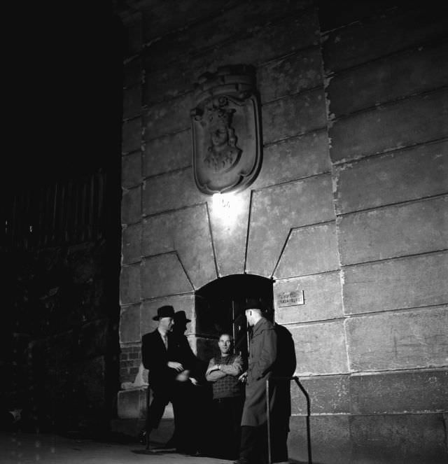 Three men outside the entrance to the bachelor hotel Kronoberg, 54 Bergsgatan, Kungsholmen.