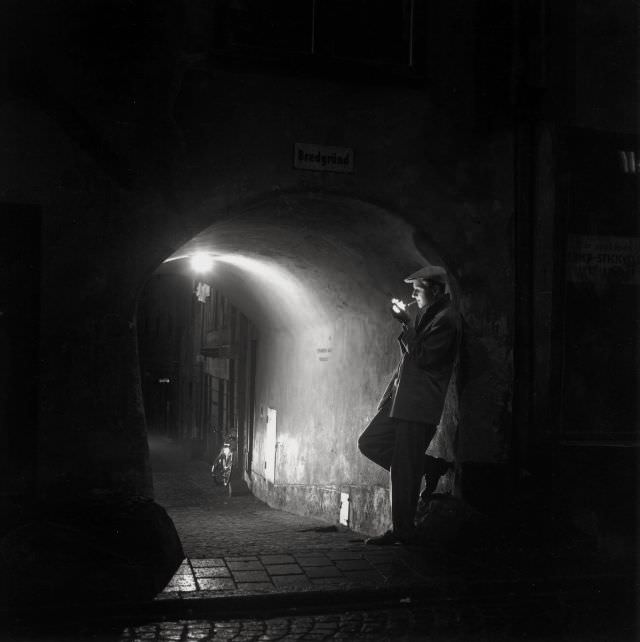 Man lighting a cigarette at Bredgränd, Gamla stan.