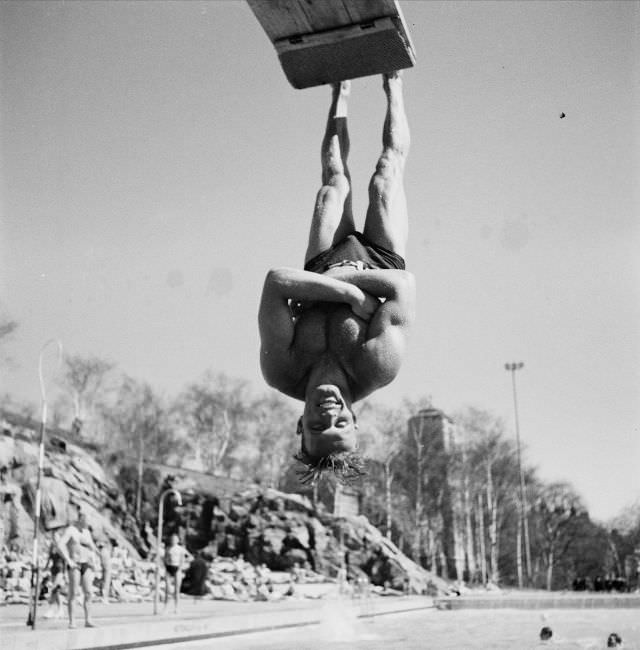 A man hanging upside down from the trampoline in his feet at the Vanadisbadet.