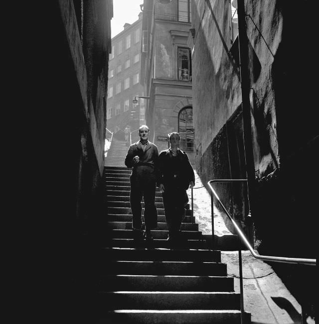 Two warehouse workers walking down Maria Trappgränd in Södermalm.