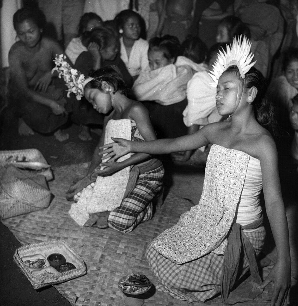 Balinese traditional dancers sprinkle holy water over the singers and themselves and ask the goddesses to 'go home, go home', 1951.