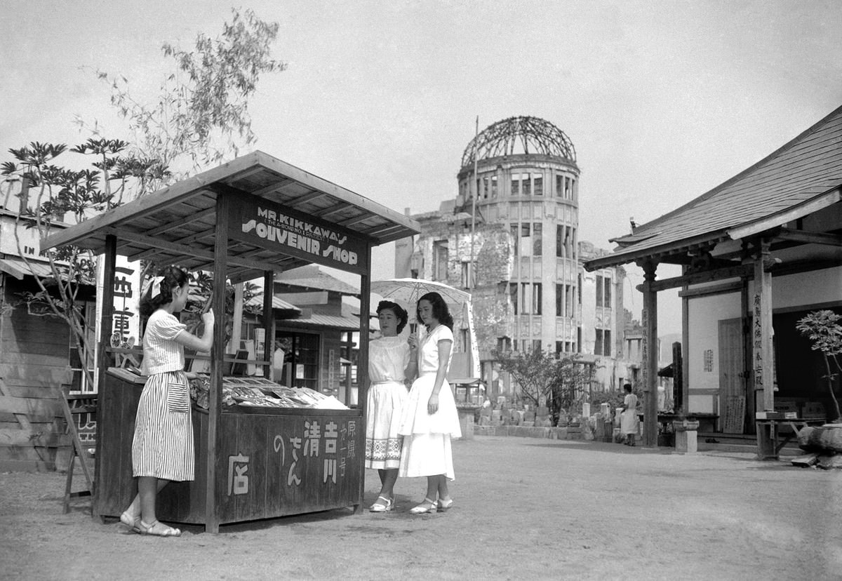 On August 3, 1951, six years after an atomic bomb was detonated above this spot in Hiroshima, a souvenir shop stands in the street near the shattered dome of the Industry Hall.