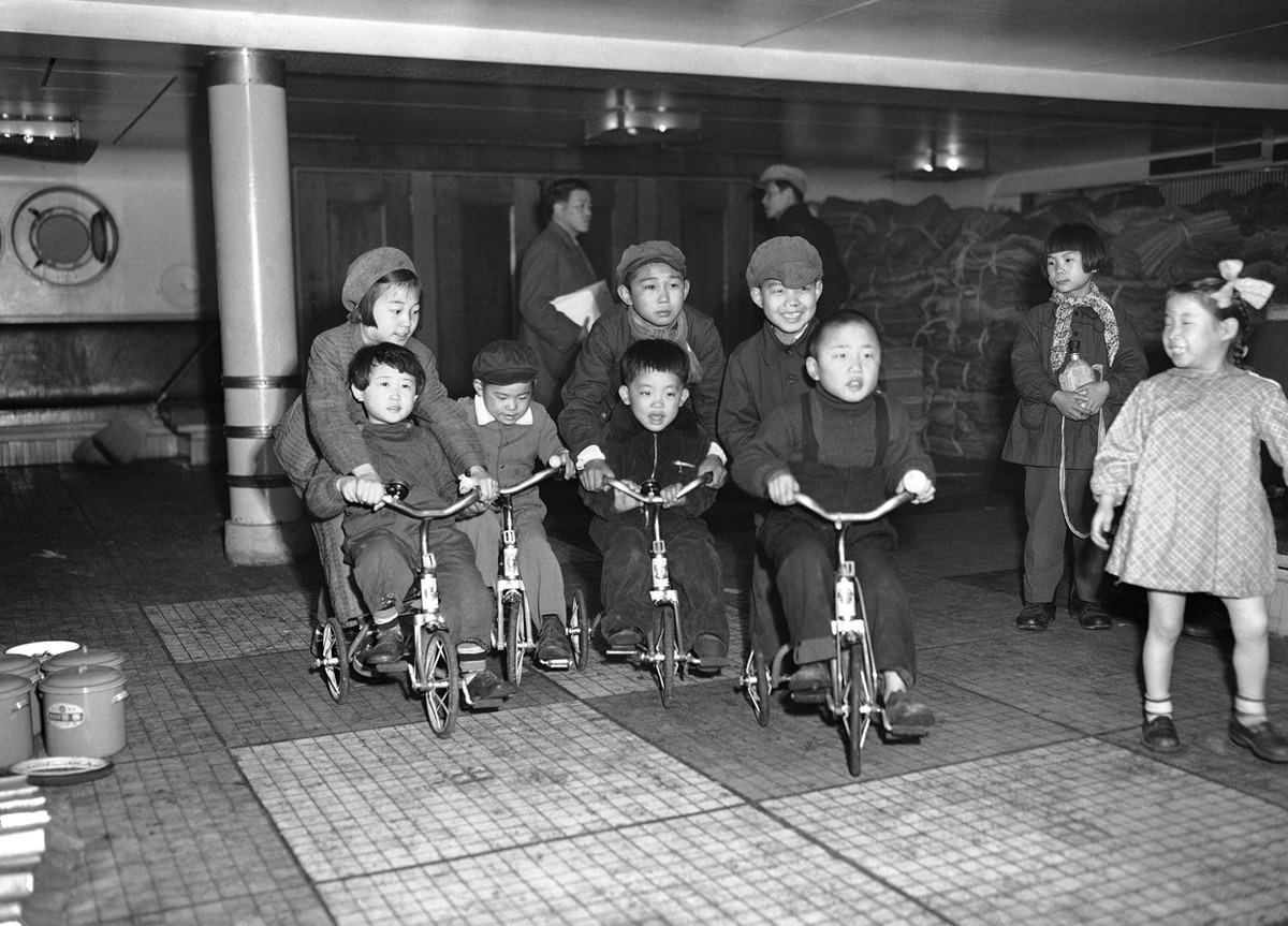 Children of repatriated families scoot around the deck of the Koan Maru as their parents prepare to disembark at Maizuru Bay, Japan, on March 24, 1953.