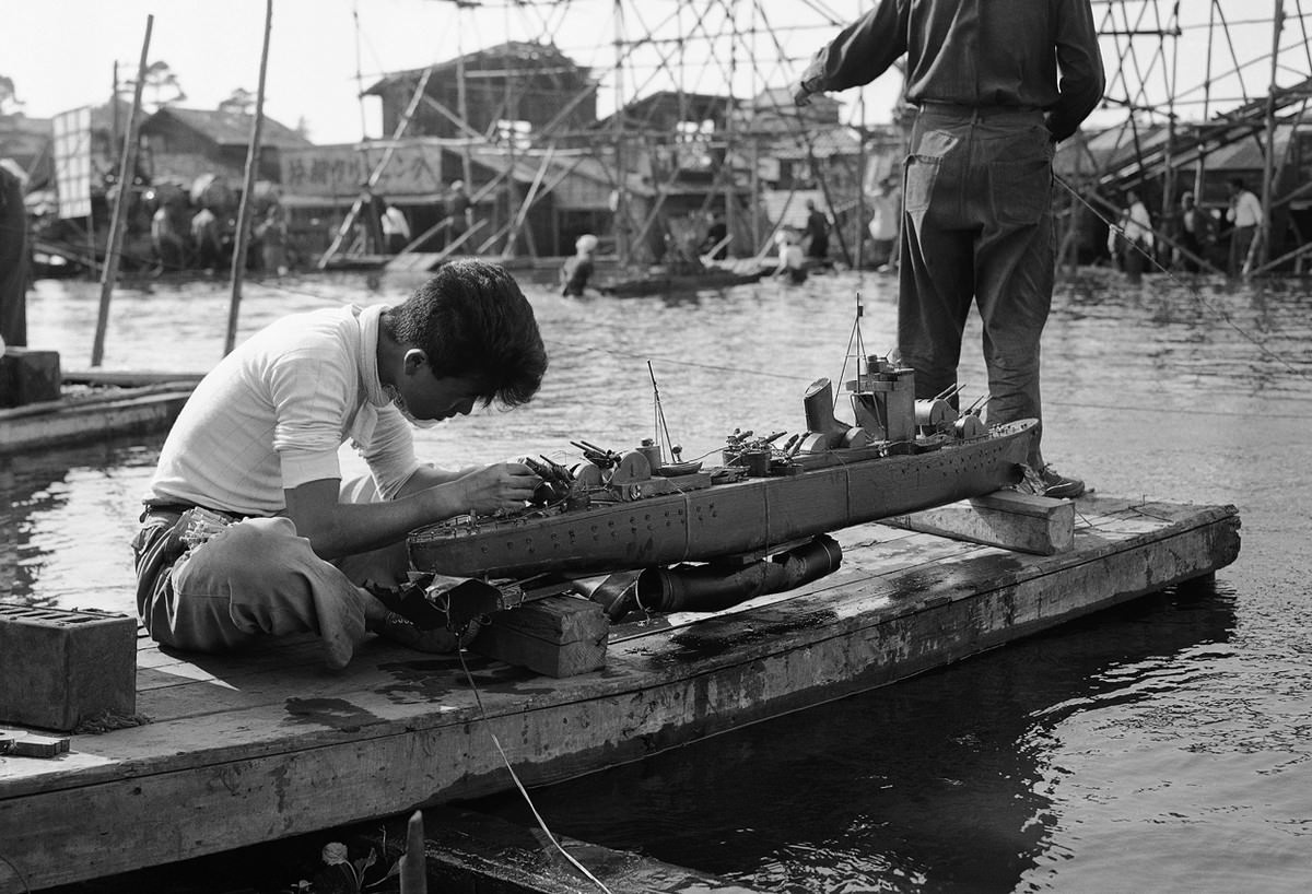 A movie studio workman rigs up one of the scale model warships used in filming a battle scene in a Japanese documentary that tells the story of the last day of the battleship Yamato, on June 8, 1953.
