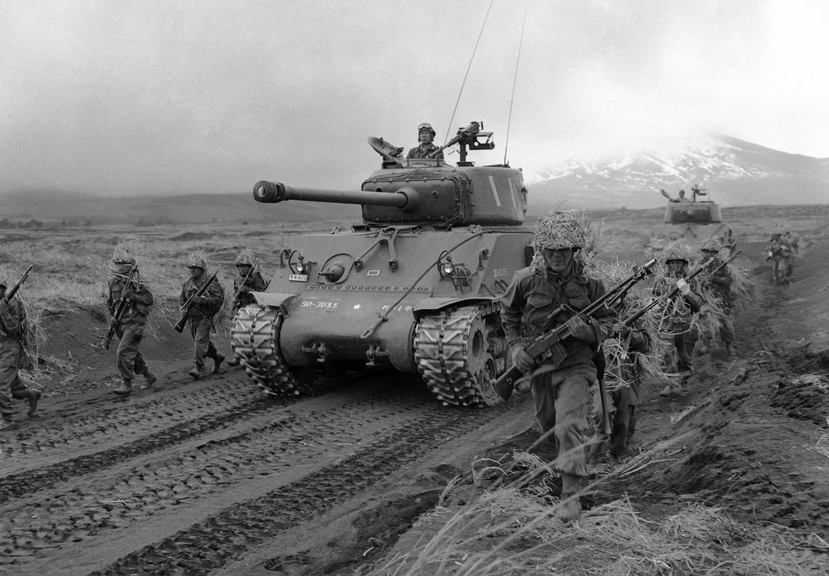 The transition from former enemy to ally is evidenced by these GI-clad Japanese army volunteers during maneuvers at the Fuji Army School outside of Tokyo on May 15, 1957.