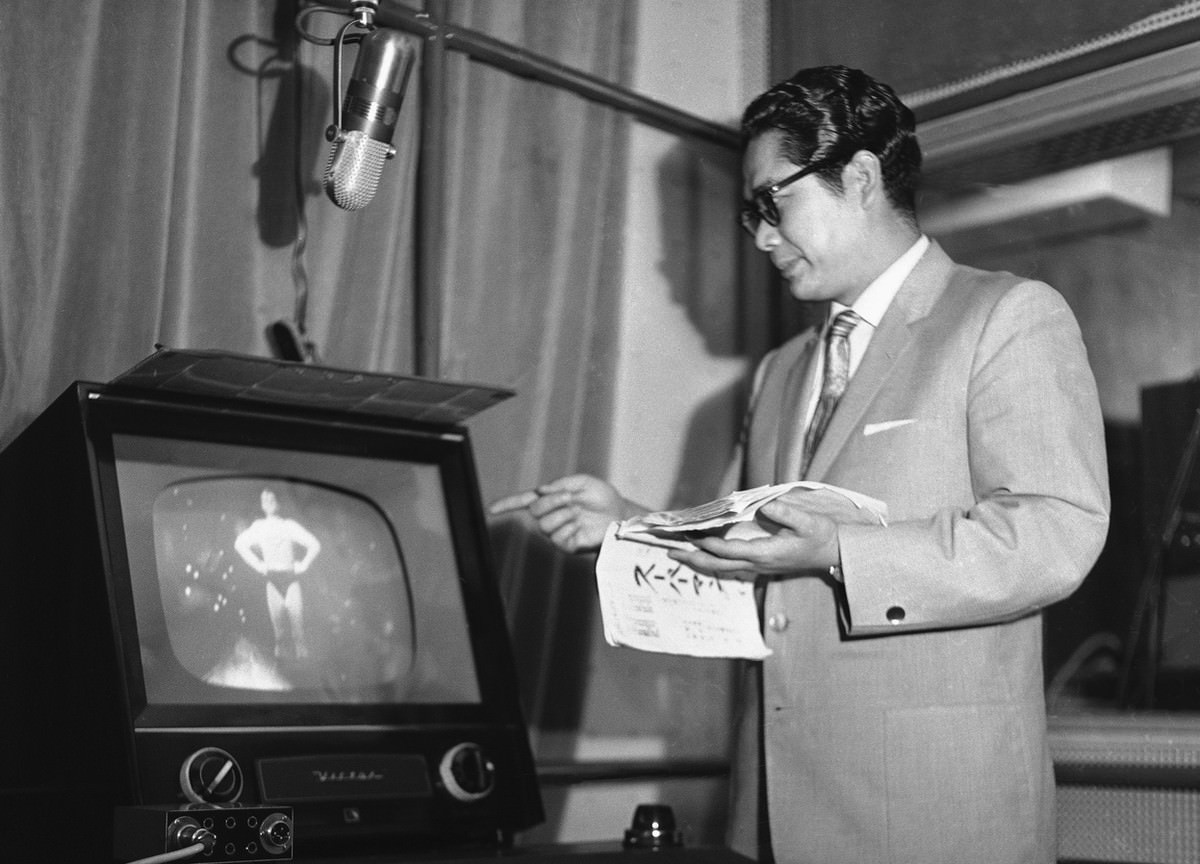 Tooru Ohira, the Japanese voice of television's Superman, watches actor George Reeves closely while he dubs Japanese words for the show on July 7, 1959.