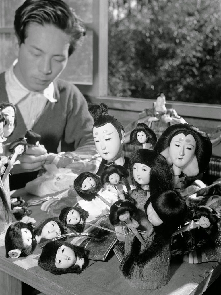 The heads all painted and the hair glued on, this Tokyo doll maker gets dolls ready for dressing in Tokyo on Jan. 26, 1950.