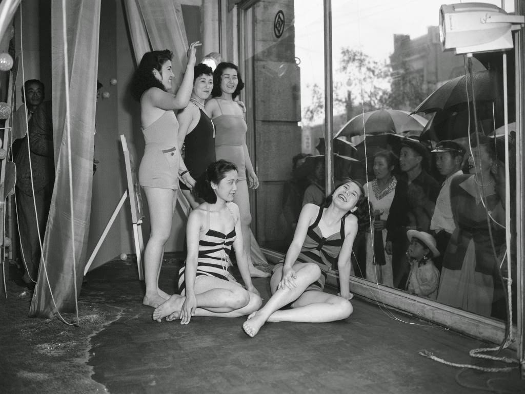 To draw the public'’s attention to a new line of bathing suits, a Tokyo department store uses live models to show off the suits, June 5, 1950.
