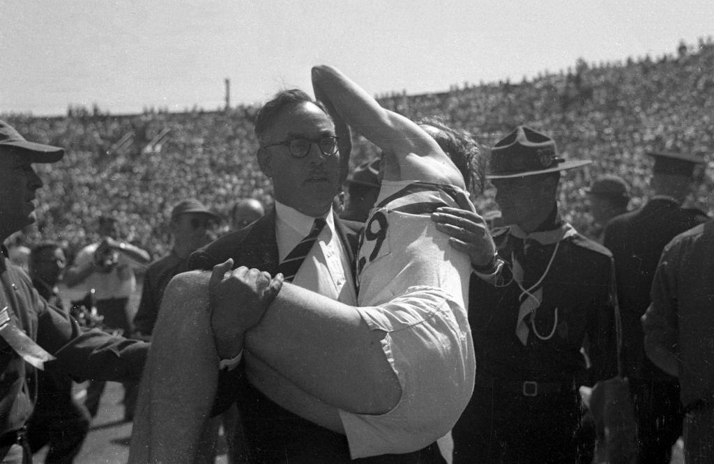 Great Britain Roger Bannister being carried by manager after mile race at Empire Stadium, Vancouver, 1954.