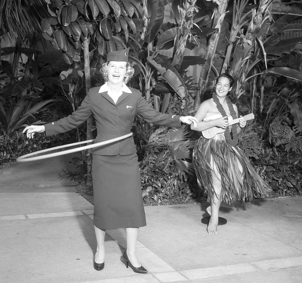 Canadian Pacific Airlines stewardess Helen Phillips of Vancouver tries out a hula hoop, 1959.