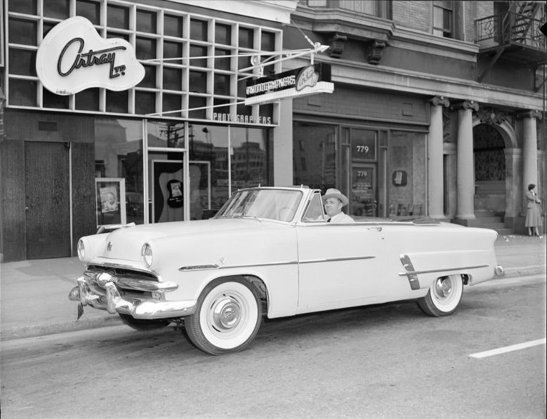 Man in convertible parked outside Artray photograph Studios, ,781 Burrard Street, Vancouver, 1953
