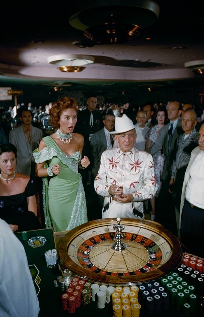 People rolling dice at craps table at casino, Las Vegas, 1960