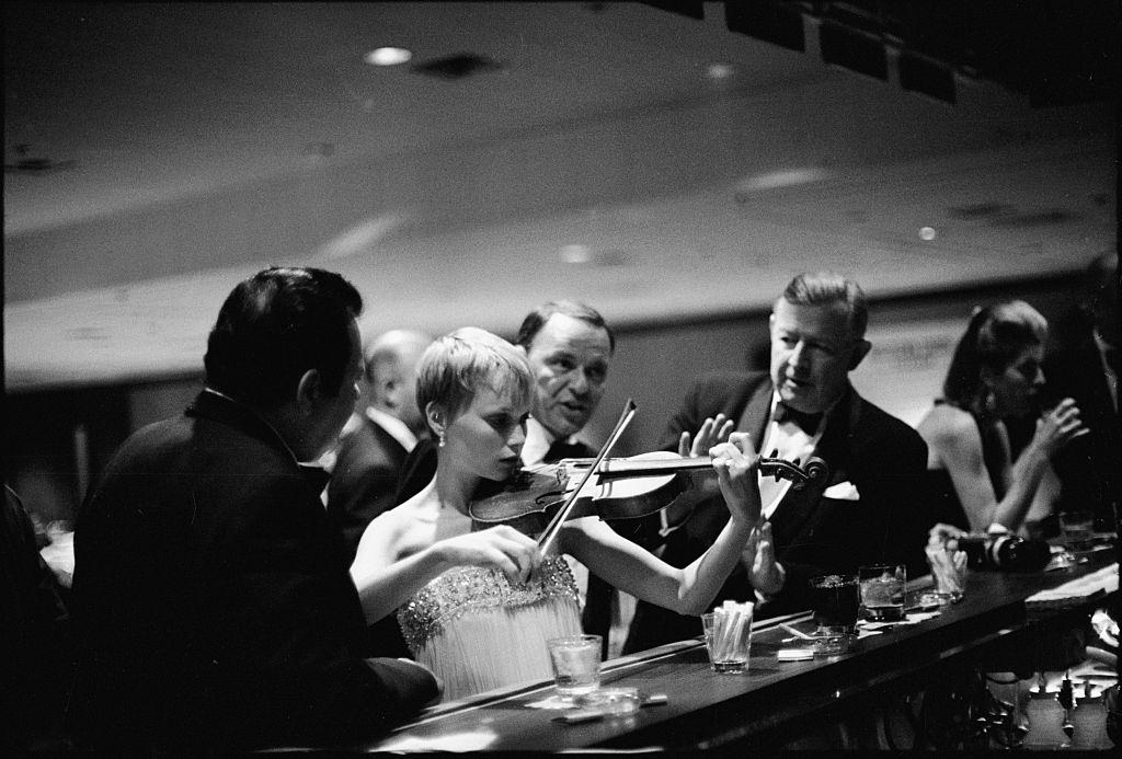 Actress Mia Farrow and plays a violin, Las Vegas, 1966.