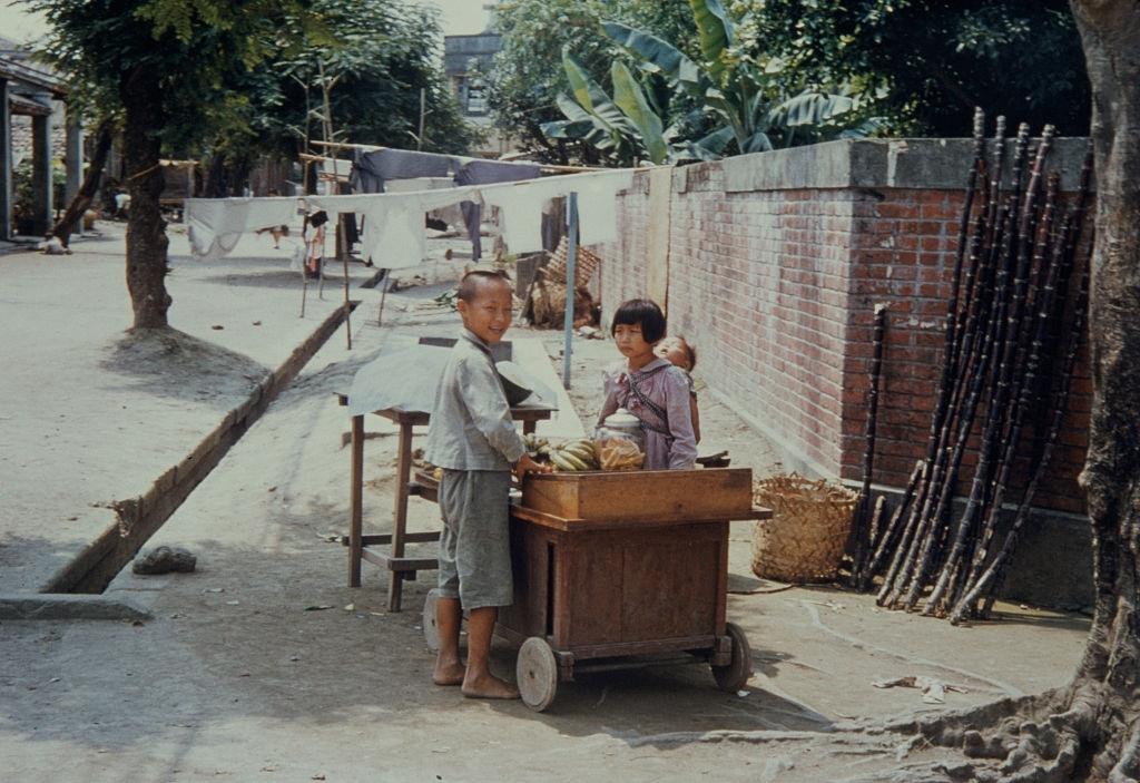 A girl selling bananas from a sidewalk stall in Pingtung County, Taiwan, circa 1965.