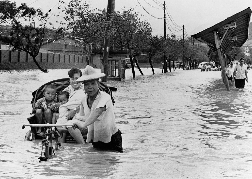 A mother put her children in an Amphibiuous Rickshaw after the Floods, in Taipei, Taiwan, on September 15, 1962.