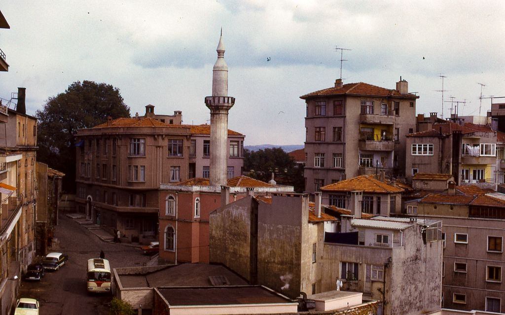 A single white minaret rising above the surrounding apartment buildings in a neighborhood of Istanbul, 1973.