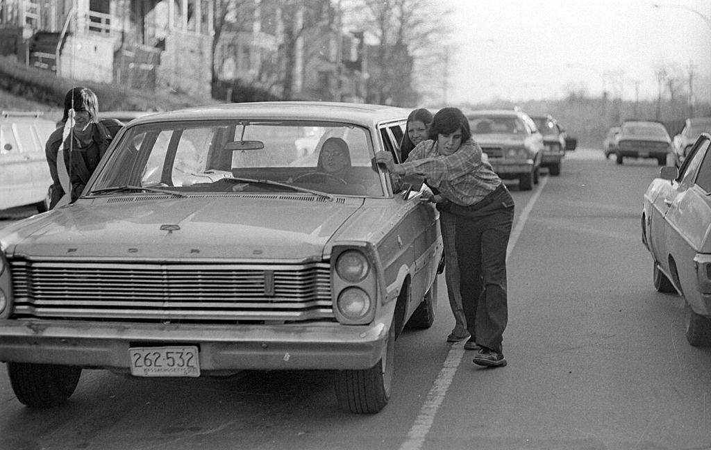 Drivers push cars to gas station during 'oil crisis,' Roslindale, Boston, Massachusetts, 1973.