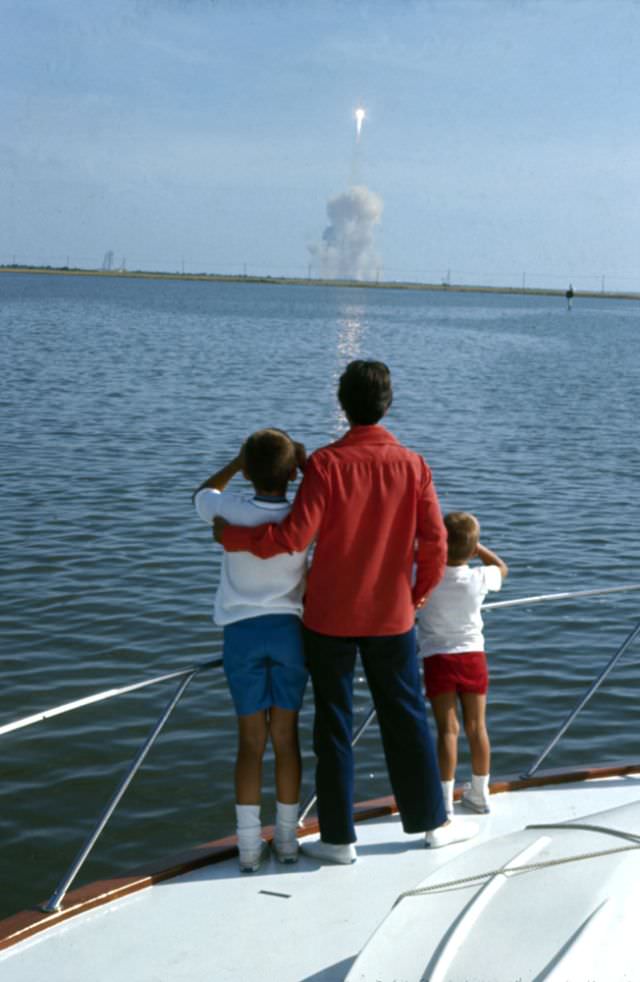 From the deck of a boat, Janet Armstrong and her sons Mark and Rick, watch the launch of NASA’s Apollo 11 mission to the moon.