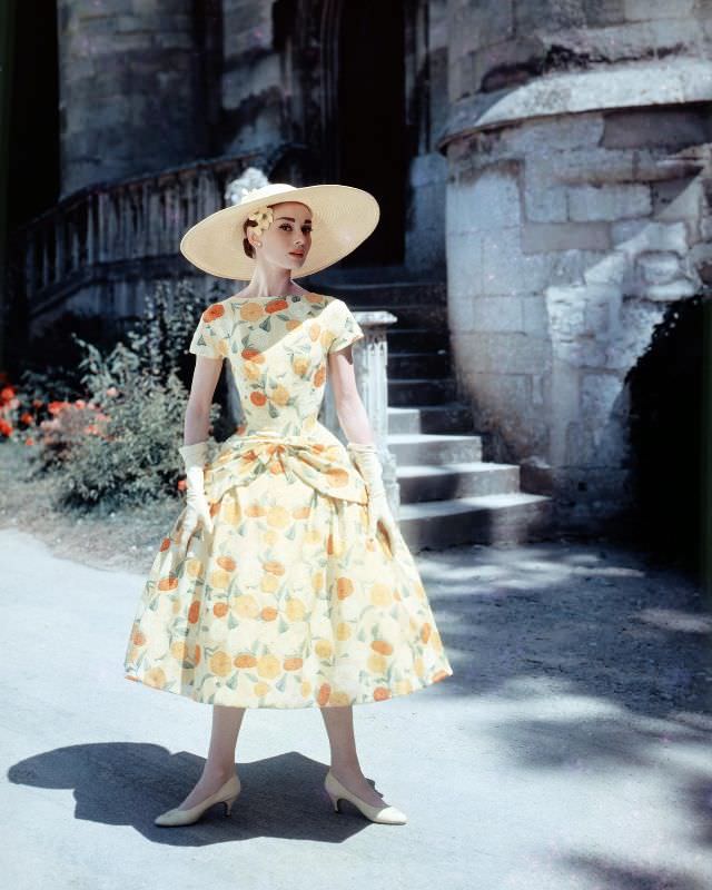 Audrey Hepburn in a floral-print day dress and sun hat on the set of 'Funny Face,' 1957.