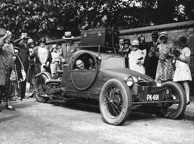 Mr. Graham's novel three-wheel car designed to look like an armoured car, being used to take himself and his bride on honeymoon after their wedding.