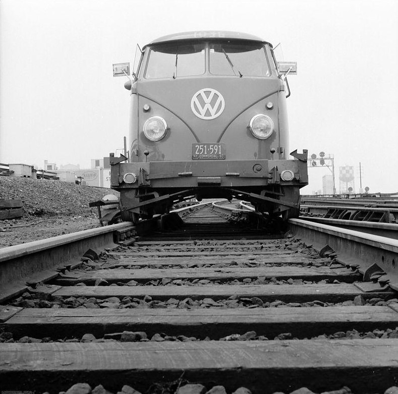 Volkswagen travelling along the tracks of the Long Island railroad.