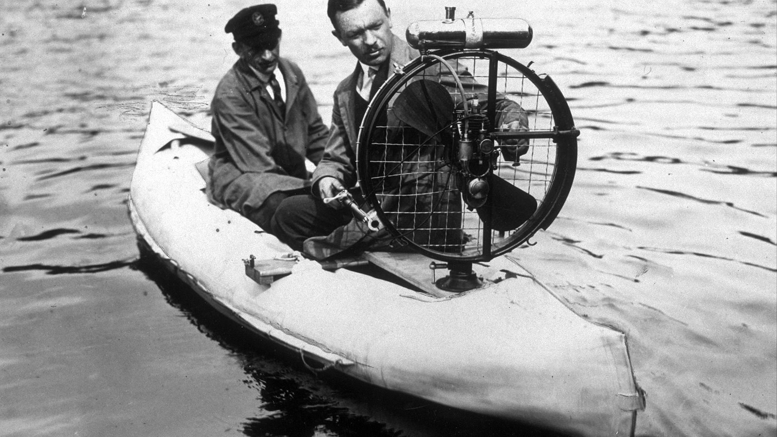 A blow-up motorized canoe, powered by an air-propeller, being tested by its inventor in 1935.