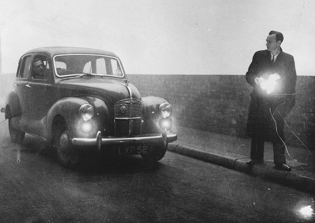 A man guiding an Automobile through the street by the torch, 1952.