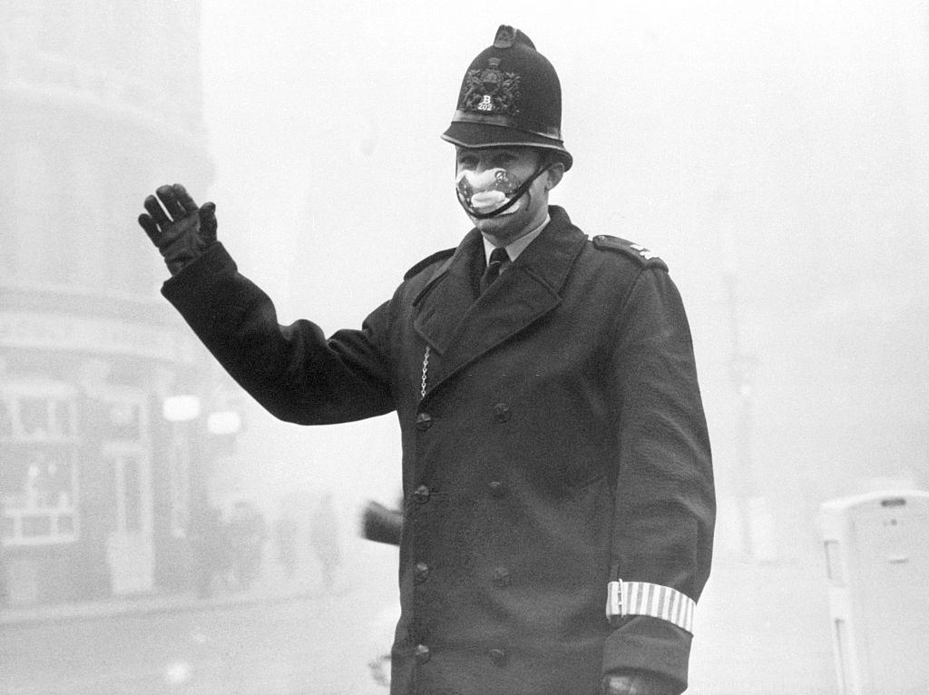 Police constable John Finn, on duty at Old Bailey wears one of the special smog mask issued to members of the London Police force, 1952.