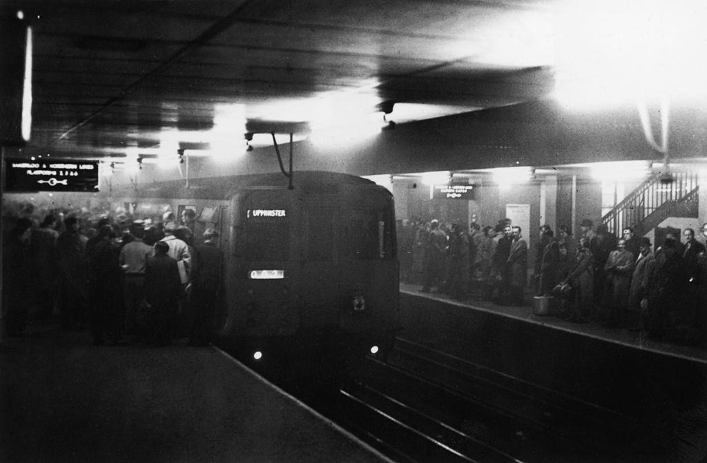 Large numbers of people using the underground system to get around London during a period of heavy smog, 8th December 1952.